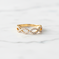 Lab-grown diamond infinity ring in yellow gold on white marble
